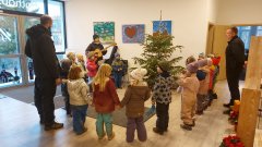 Vorschulkinder schmücken Weihnachtsbaum